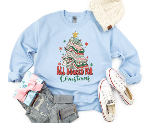 All Booked for Christmas crewneck featuring a design with books stacked in the shape of a Christmas tree, perfect for book lovers celebrating the holiday season.