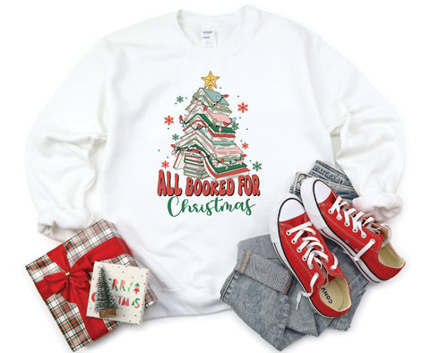 All Booked for Christmas crewneck featuring a design with books stacked in the shape of a Christmas tree, perfect for book lovers celebrating the holiday season.