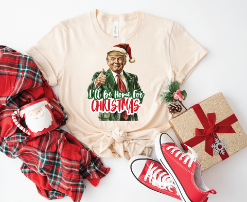 Trump "I'll Be Home for Christmas" softstyle shirt featuring a humorous design, perfect for celebrating the holiday season with a playful touch.